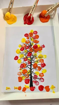 an art project with paint and watercolors on the tray, including a tree