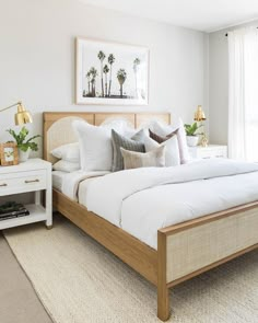 a bed with white sheets and pillows in a bedroom