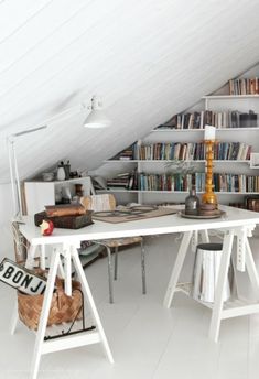 an attic office with bookshelves and desk