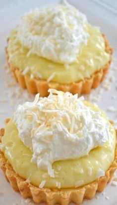 two cupcakes with whipped cream and coconut on top