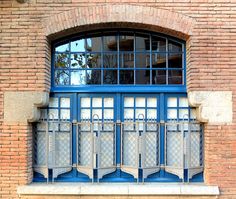 an arched window with blue trim on a brick building