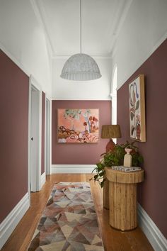 the hallway is decorated in shades of pink and brown, with an area rug on the floor