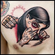 a woman's chest with tattoos on it and two fingers in the middle of her hand