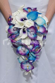 the bride's bouquet was made from orchids and calla lilies in shades of blue