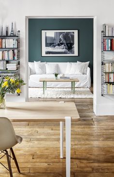 a living room filled with furniture and bookshelves next to a dining room table