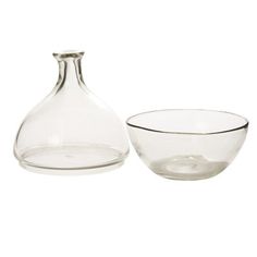 an empty glass bottle and bowl on a white background