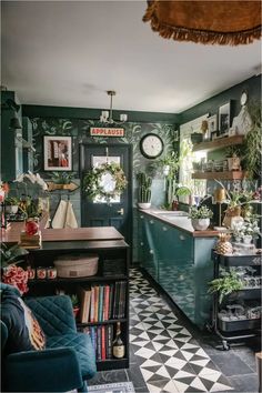 the kitchen is decorated in green and black with lots of greenery on the walls