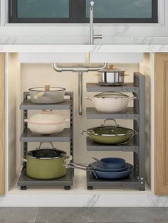 an open cabinet with pots and pans in it