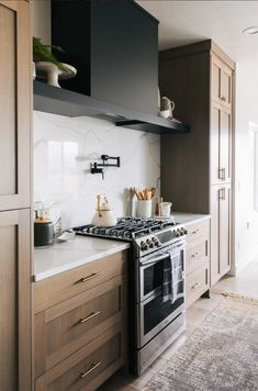 a stove top oven sitting inside of a kitchen next to wooden cabinets and counter tops