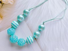 the necklace is decorated with blue and white beads