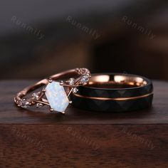 two wedding rings sitting on top of a wooden table with white and black diamond accents