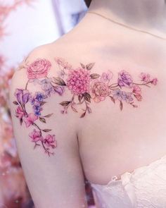 the back of a woman's shoulder with pink flowers on her left arm and chest