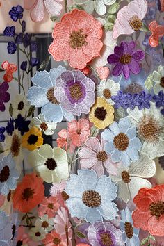 an assortment of flowers are hanging on the wall