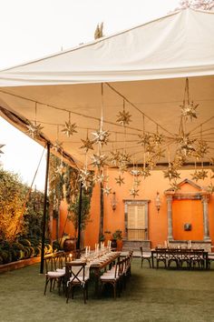 an outdoor dining area with tables, chairs and umbrellas set up for a party