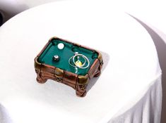 a miniature pool table on top of a white cloth