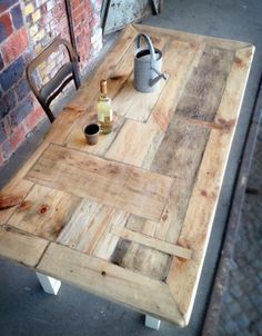 a wooden table with two buckets on it next to a brick wall and chair