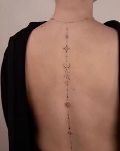 the back of a woman's neck with a cross and star tattoo on it