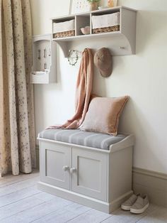 a white bench sitting under a window next to a shelf