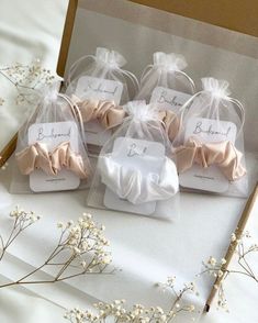 four small favors are wrapped in organ - ribbon and tied with twine bow ties