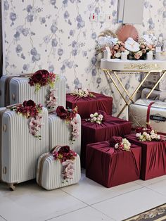 several pieces of luggage sitting on the floor next to each other in front of a floral wallpaper