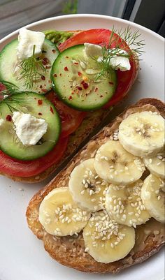 a sandwich with cucumbers, tomatoes and other toppings on a white plate