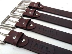 three brown leather straps with metal handles