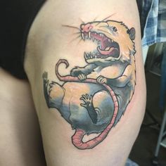 a woman's thigh with a rat on it and an animal in the middle