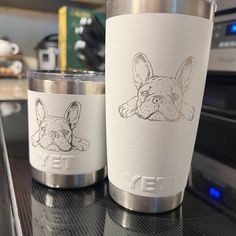 two stainless steel cups sitting on top of a counter