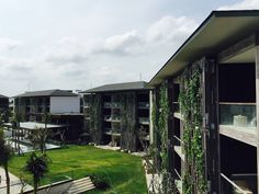 an apartment complex with lush green grass and plants growing on the side of the building