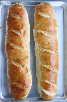 two loaves of bread sitting on top of a pan