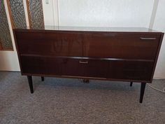 a brown cabinet sitting on top of a carpeted floor