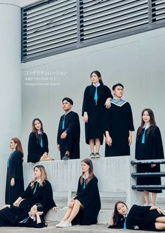 a group of people in graduation gowns sitting on steps