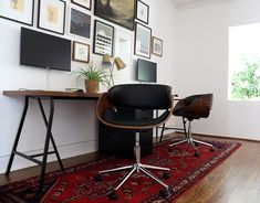 a room with a desk, chair and pictures on the wall