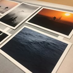 four different pictures are displayed on a table with the sun setting in the distance behind them