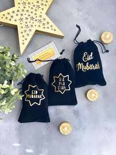 three black drawsacks with gold foil stars on them