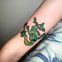 a person with a tattoo on their arm that has an image of a green dragon