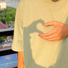 a man holding his hand out in front of him with a shadow on the shirt