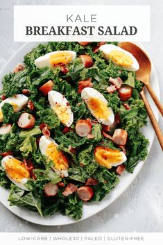 kale breakfast salad with hard boiled eggs, bacon and lettuce on a white plate