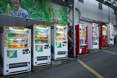 several vending machines lined up next to each other on the side of a road