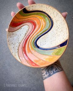 a person holding a colorful bowl in their hand