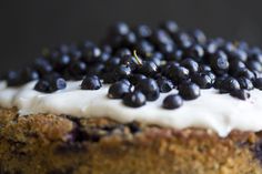 a cake with blueberries and cream frosting on top