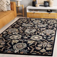 a living room area with a couch, coffee table and rugs on the floor