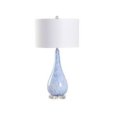 a blue glass table lamp with a white shade on the base and a white fabric lampshade