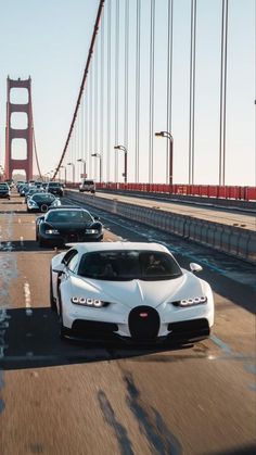 the white bugatti is driving down the road by the bridge in front of it