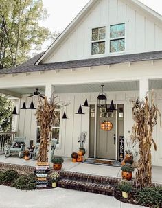 a white house with pumpkins on the front porch