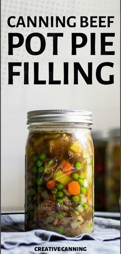 a jar filled with canned food sitting on top of a table next to a sign that says canning beef pot pie filling