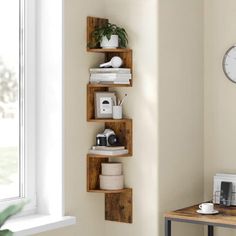 three wooden shelves on the wall near a table with a coffee cup and other items