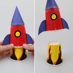 a hand holding a paper cup with a rocket ship design on the top and bottom