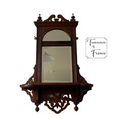 an ornate wooden mirror hanging on the wall