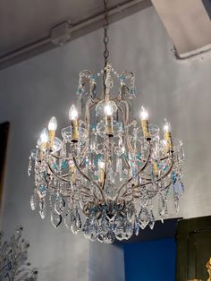 a crystal chandelier hanging from the ceiling in a room with blue walls and gold accents